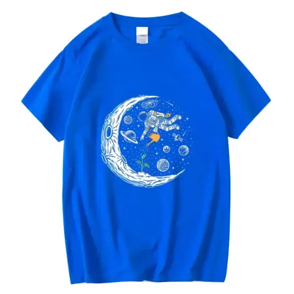 T-shirt bleu avec un motif d'astronaute flottant dans l'espace, entouré de planètes, étoiles et une lune stylisée. Parfait pour les amateurs de science et d'astronomie.