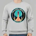 Sweatshirt gris avec logo Falcon Heavy SpaceX, illustration d'une fusée en lancement dans un style graphique moderne, idéal pour les amateurs d'espace et de technologie.