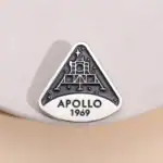 Une broche ou badge représentant la mission Apollo 11 de la NASA, avec la date 1969, symbole emblématique de l'exploration spatiale.