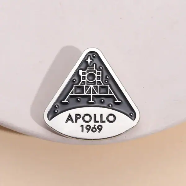 Une broche ou badge représentant la mission Apollo 11 de la NASA, avec la date 1969, symbole emblématique de l'exploration spatiale.