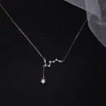 Collier délicat avec pendentif étoile et constellation, en métal précieux, parfait pour les amateurs d'astronomie et de bijoux élégants.