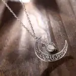Collier avec pendentif lune en métal finement gravé et pierre centrale, idéal pour une touche élégante et mystique.