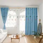 Rideaux à thème spatial pour chambre d'enfant, décorations de science, étoiles, planètes, fusées, dans une pièce lumineuse avec mobilier blanc et plantes vertes.