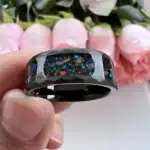 Un anneau en résine noire avec des inclusions de couleurs vives, évoquant un univers cosmique ou scientifique, parfait pour les amateurs de science et de décoration unique.