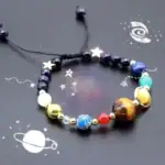Bracelet cosmique avec perles représentant différentes planètes et étoiles, idéal pour les amateurs d'astronomie et de décoration scientifique.