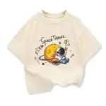 Vêtement enfant avec motif d'astronaute et planète, illustrant un voyage spatial avec une fusée, une planète et un astronaute en combinaison.