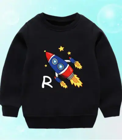 Sweatshirt pour enfant noir avec motif de fusée colorée et étoiles, parfait pour les amateurs de science et d'astronomie. Confortable et tendance, idéal pour les jeunes passionnés d'espace.