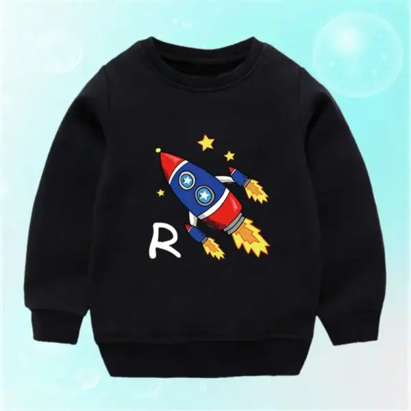 Sweatshirt pour enfant noir avec motif de fusée colorée et étoiles, parfait pour les amateurs de science et d'astronomie. Confortable et tendance, idéal pour les jeunes passionnés d'espace.