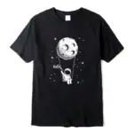 T-shirt noir avec illustration d'un astronaute suspendu à la lune, accompagnée du mot "Hello" dans un style graphique simple et moderne.
