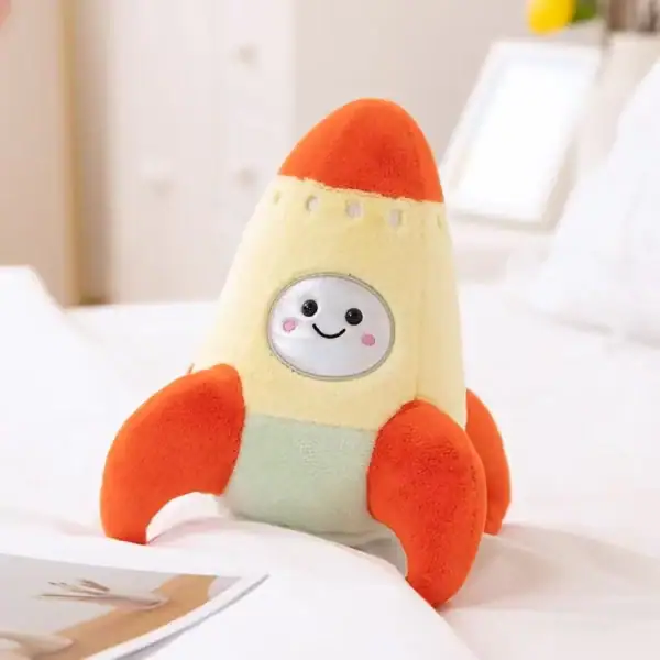 Peluches scientifique adorable représentant une fusée avec un visage souriant et des couleurs vives orange et beige.