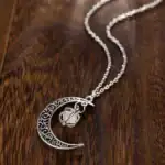 Pendentif lune en métal argenté avec bracelet à chaîne, bijou de style cosmique et mystique.