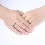 Deux mains portant des bagues en acier inoxydable avec motifs scientifiques, symbolisant l'amour et la passion pour la science.
