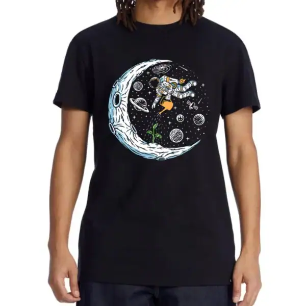 T-shirt noir avec illustration d'un astronaute flottant dans l'espace, entouré de planètes, étoiles et de la lune, parfait pour les amateurs de science et d'exploration spatiale.