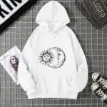 Vêtement à capuche blanc avec design solaire et lunaire.
