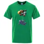 T-shirt vert avec motif d'astronaute et planètes suspendues, idéal pour les amateurs d'espace et de science.