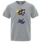 T-shirt gris avec illustration d'un astronaute flottant dans l'espace sous un groupe de planètes colorées. Parfait pour les amateurs de science et d'astronomie.