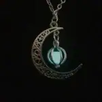 Pendentif lune en acier inoxydable avec une boule lumineuse suspendue, idéal pour une décoration mystique ou un accessoire de mode original.