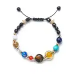 Bracelet ajustable avec perles de différentes couleurs et formes, orné d'étoiles dorées, parfait pour les amateurs de science et de décoration inspirée de l'univers.