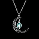 Pendentif en forme de lune avec un motif orné et un pendentif moléculaire en verre bleu, suspendu à une chaîne en argent. Un bijou scientifique élégant et original.