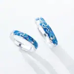Anneaux en argent avec motif océanique en émail bleu, inspirés par la mer et les vagues, parfaits pour les amateurs de thèmes marins et de design élégant.