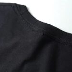 VĂȘtement noir uni, prĂšs du col, en tissu doux et confortable.