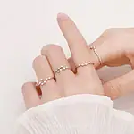 Anneaux en forme de constellation, bijoux délicats et élégants, portés sur une main avec un fond blanc.