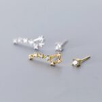 Boucles d'oreilles en forme de molécules avec pierres précieuses, design élégant et scientifique, parfaites pour les amateurs de science et de bijoux sophistiqués.