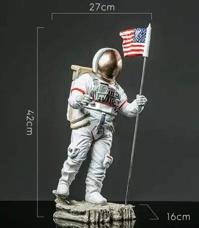 Vêtement d'astronaute en figurine avec drapeau américain, hauteur 42 cm, dimensions 27x16 cm, représentant un explorateur spatial en tenue complète, debout sur une base rocheuse.