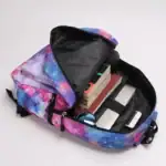 Sac à dos avec motif galaxie, idéal pour étudiants ou amateurs de science, contenant livres, téléphone et autres accessoires.