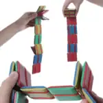 Jeu de blocs colorés empilés et suspendus, illustrant un puzzle éducatif pour stimuler la motricité et la coordination chez les enfants.