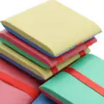 Ensemble de blocs-notes colorés empilés avec élastiques, parfaits pour la prise de notes et l'organisation de bureau.