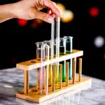 Test de laboratoire avec tubes à essai colorés dans un support en bois.
