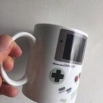 Tasse en forme de console Nintendo Game Boy, idéale pour les amateurs de jeux vidéo rétro et la décoration geek.