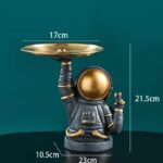 Vase décoratif en forme d'astronaute avec un plateau doré, idéal pour la décoration scientifique ou moderne.