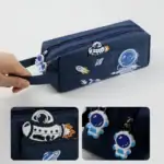 Pochette de rangement en tissu bleu marine avec motifs astronautes, fusées et planètes, idéale pour les fournitures scolaires ou accessoires.