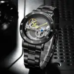 Montre squelette mécanique en acier noir avec mouvement visible, design élégant et moderne.