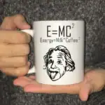 Tasse avec la célèbre équation d'Einstein E=MC² et une illustration humoristique de Einstein avec la langue sortie, idéale pour les amateurs de science et de décoration geek.