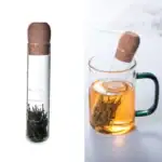 Infuseur à thé en forme de tube à essai avec feuilles de thé, idéal pour décoration scientifique ou expérience de dégustation de thé.
