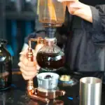 Pipette à distillation en verre utilisée pour des expériences scientifiques, avec un systÚme de chauffage et de refroidissement.