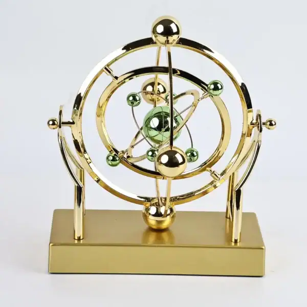 Modèle atomique décoratif en métal doré avec sphères vertes et or, représentant un atome stylisé.