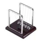 Pédule de Newton en métal brillant avec base en bois foncé, illustrant la célèbre expérience de physique pour démonstration de la conservation de l'énergie.