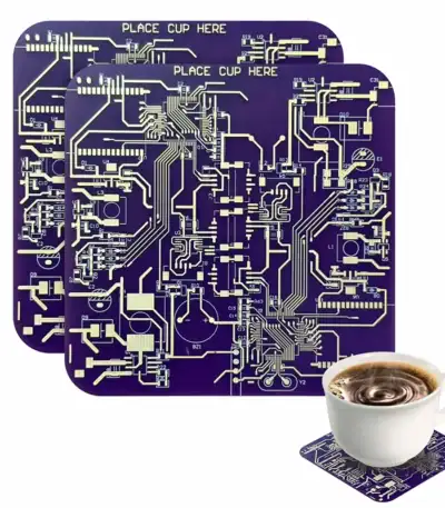Panneau de circuit imprimé violet avec inscriptions "PLACE CUP HERE" et tasse de café posée sur un circuit imprimé.