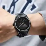 Montre scientifique noire avec cadran numérique et design futuriste, portée sur le poignet d'une personne.