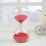 Sablier en verre transparent avec sable rouge, décoration scientifique élégante pour bureau ou maison.