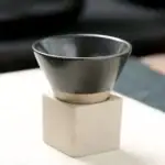 Balayette en acier inoxydable avec socle en bois pour la décoration scientifique.