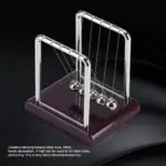 Pêndule de Newton en métal brillant avec six sphères suspendues, sur base en bois foncé, illustrant la physique et la décoration scientifique.
