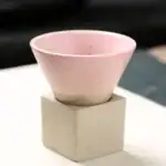 Coupe en céramique rose pastel posée sur un socle en béton, idéale pour la décoration de style scientifique ou moderne.