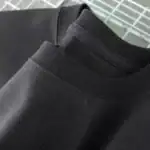 T-shirt noir en coton biologique, simple et élégant, parfait pour un style décontracté ou casual, fabriqué à partir de matériaux durables pour un confort optimal.