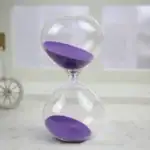 Sablier scientifique avec sable violet, symbole de la mesure du temps, idéal pour la décoration de bureau ou d'études, apportant une touche scientifique et élégante.