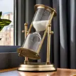 Sablier décoratif en laiton avec sable blanc, idéal pour la décoration intérieure ou comme objet de collection scientifique.